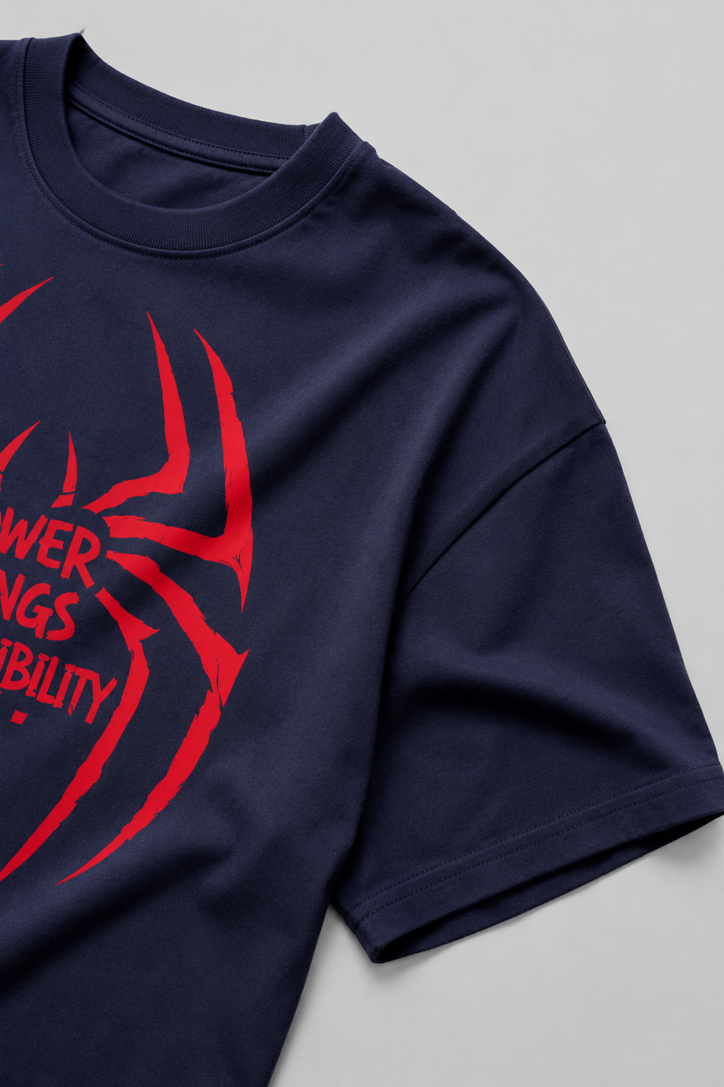 Navy blue t-shirt with red spider web design and text on a light gray background