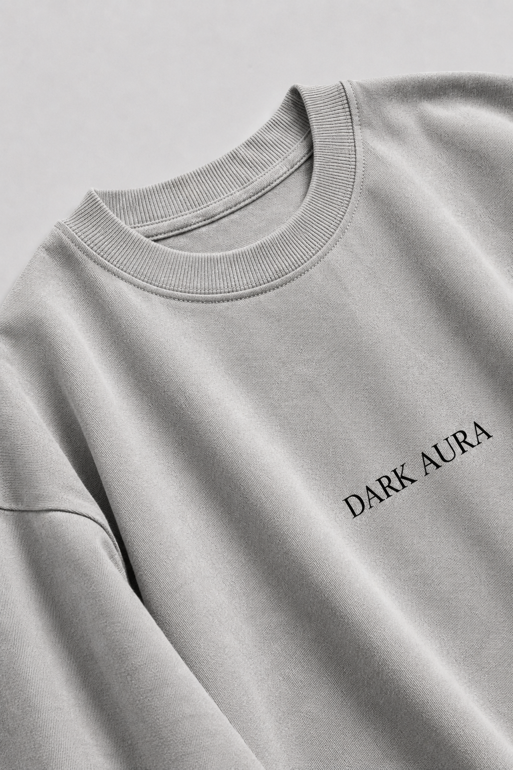 Gray sweatshirt with 'DARK AURA' text on a light gray background