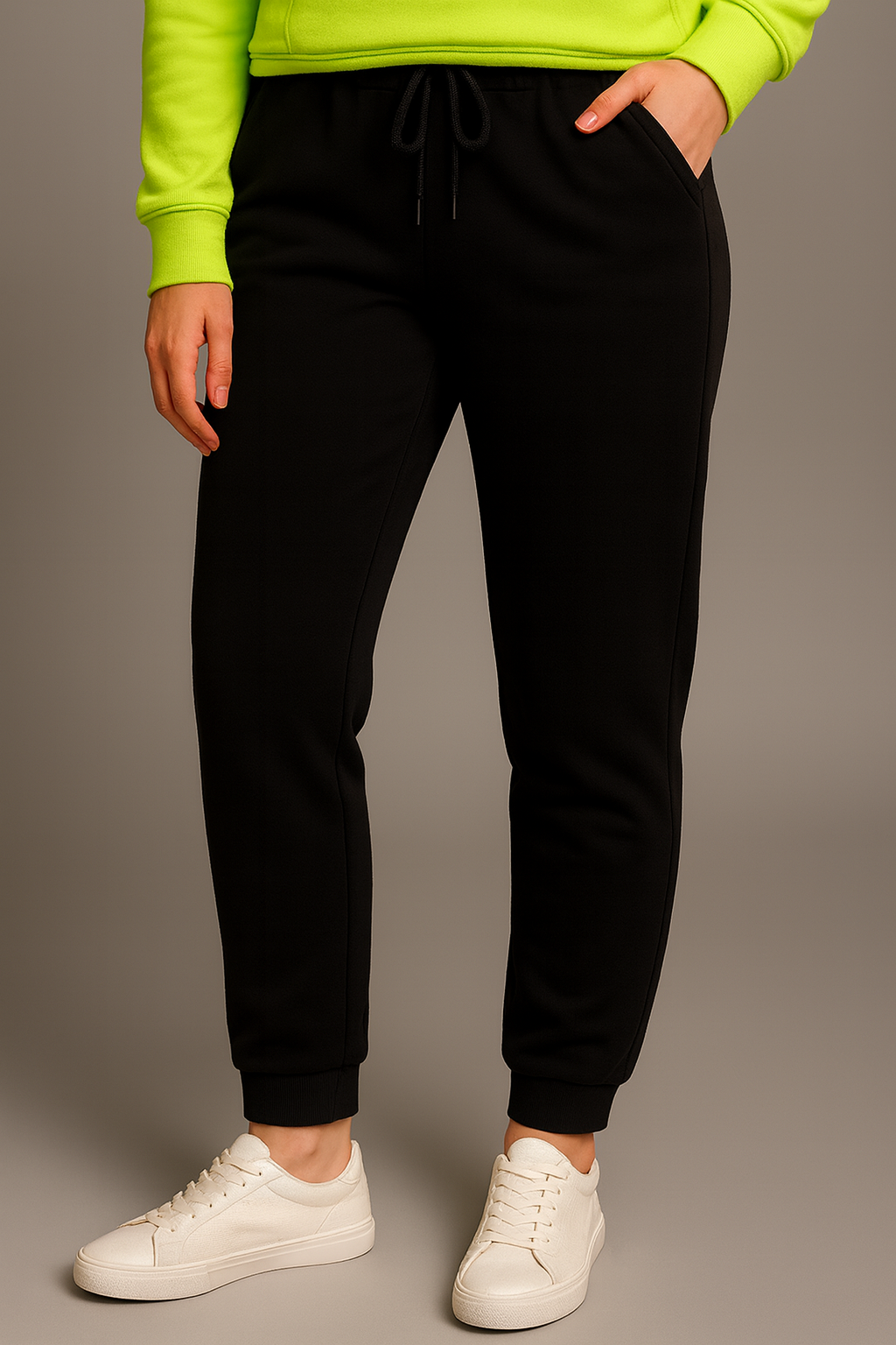 Person wearing black jogger pants with a plain background