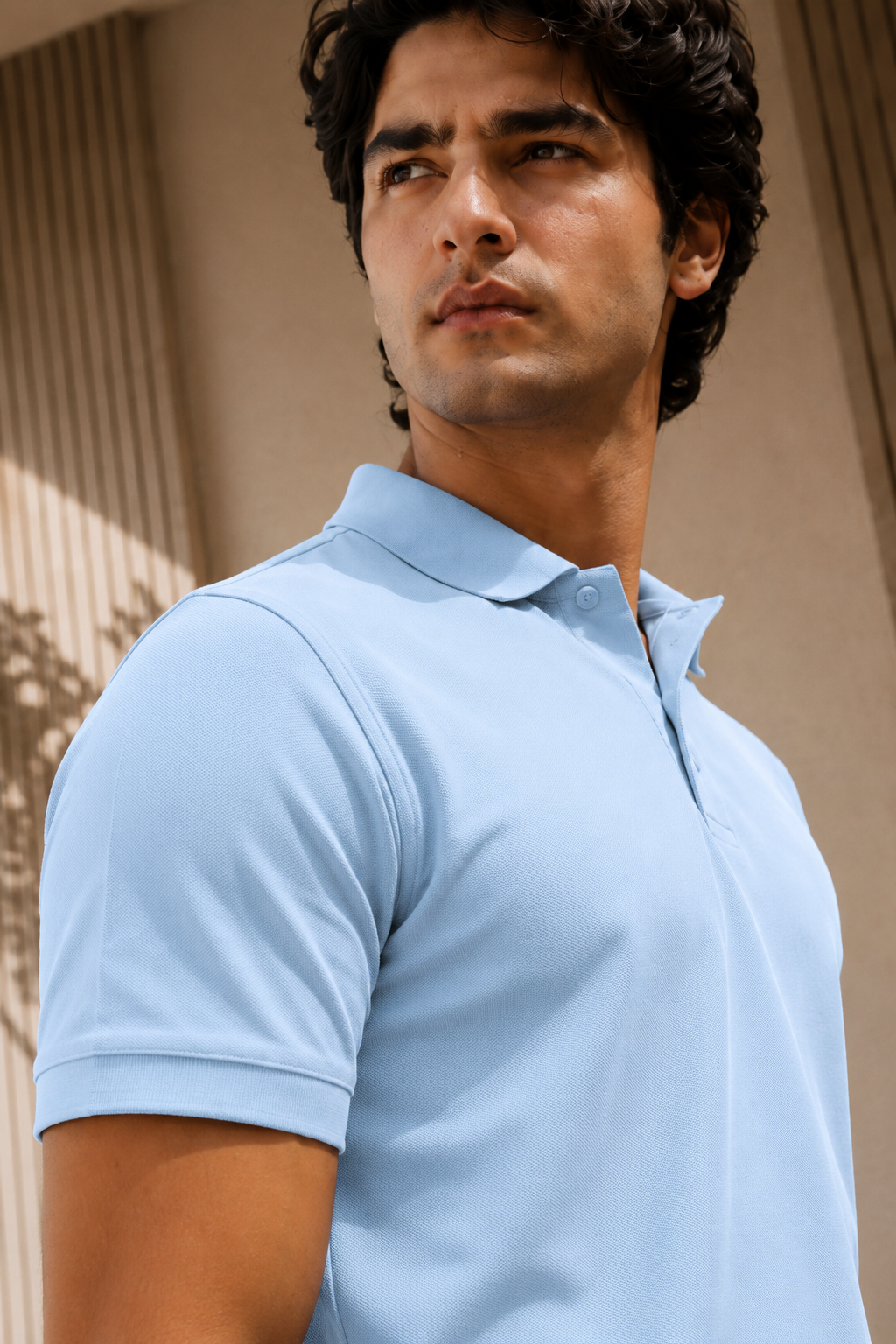 Man wearing a light blue polo shirt against a neutral background
