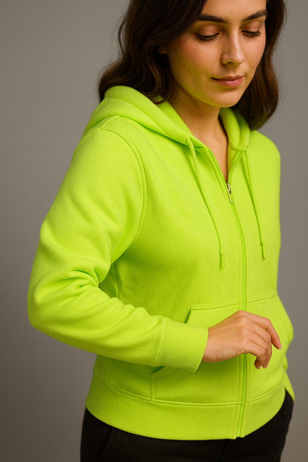 Woman wearing a bright green hoodie against a gray background