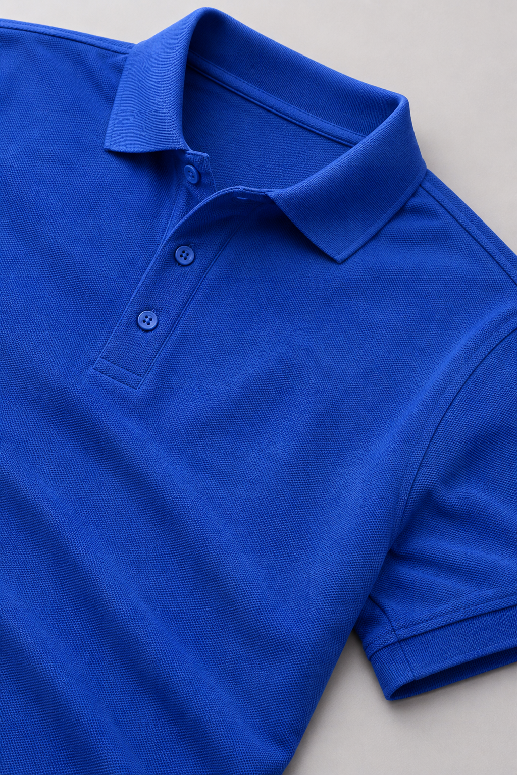 Blue polo shirt on a light gray background