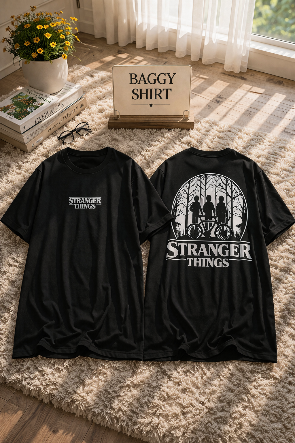 Two black 'Stranger Things' t-shirts on a textured surface with decorative items in the background.