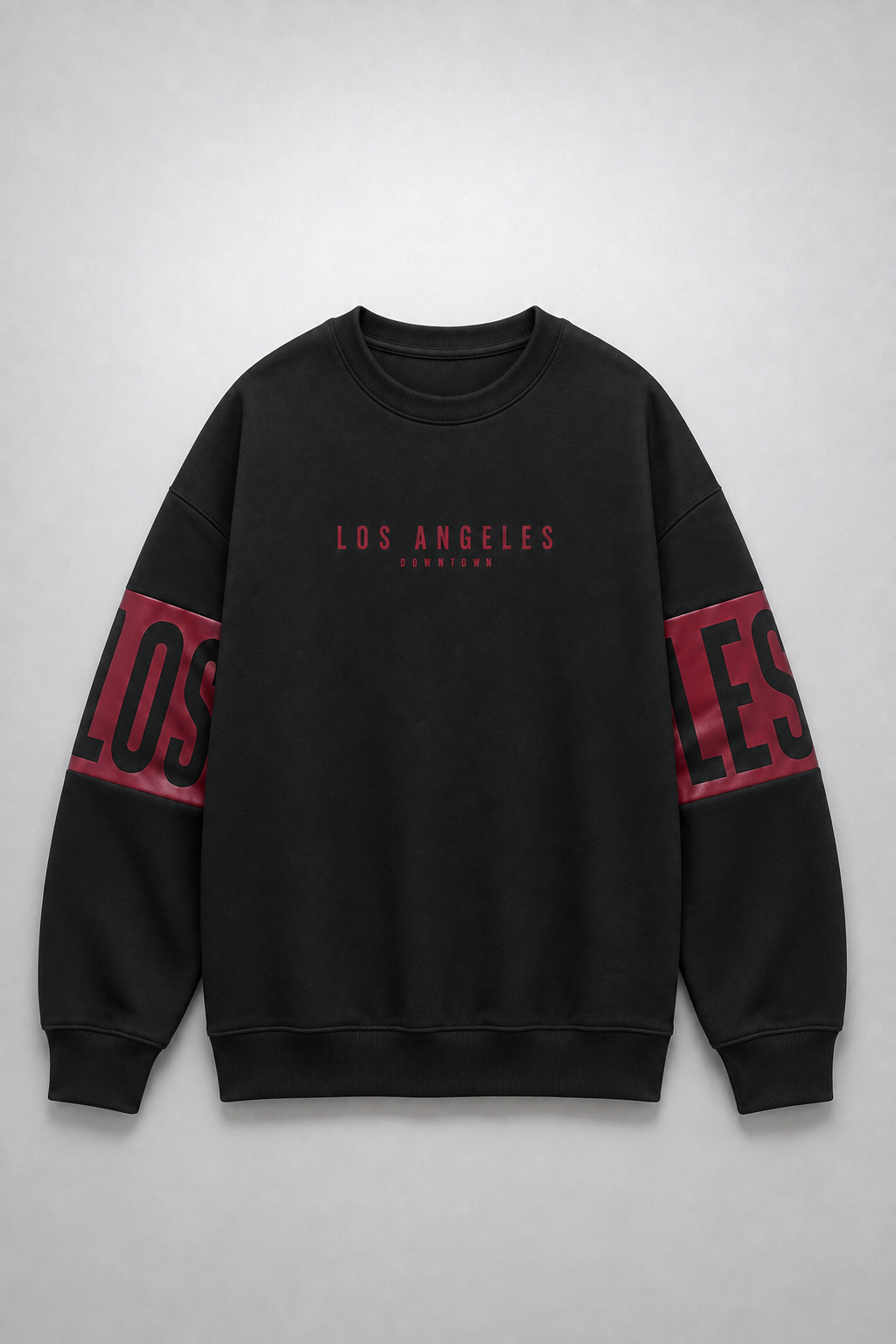 A black crewneck sweatshirt with 'LOS ANGELES' printed in red on the chest and large red and black lettering on the sleeves, displayed flat against a light gray background.