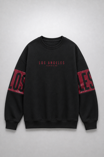 A black crewneck sweatshirt with 'LOS ANGELES' printed in red on the chest and large red and black lettering on the sleeves, displayed flat against a light gray background.