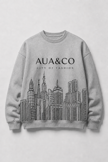 A light gray crewneck sweatshirt featuring a black line art graphic of a city skyline and the text 'AUA&CO' and 'CITY OF FASHION' printed on the chest, displayed against a neutral light gray background.