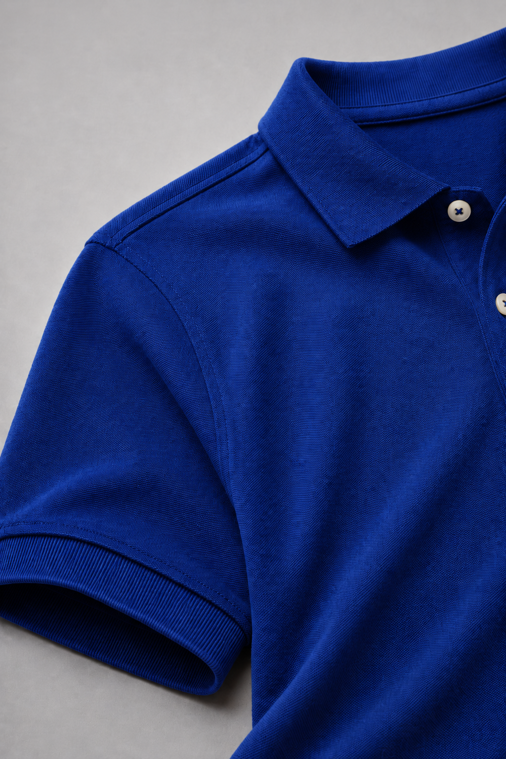 Close-up of a blue polo shirt on a gray background