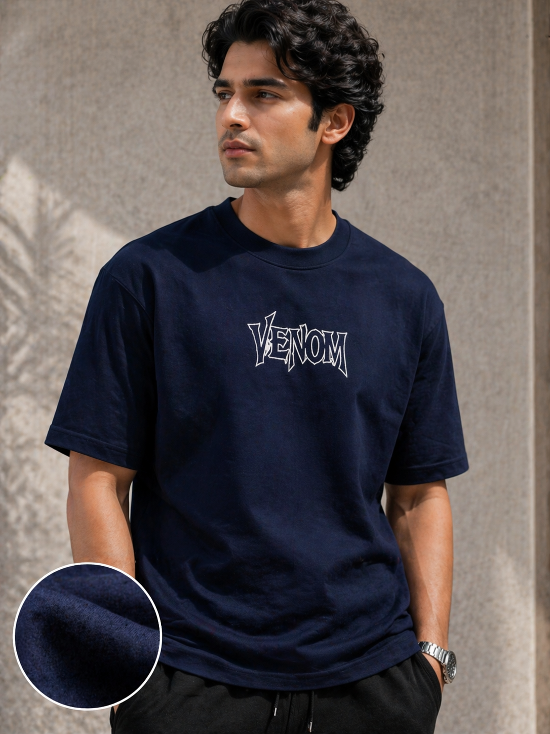 Man wearing a navy blue t-shirt with 'Venom' logo against a neutral background