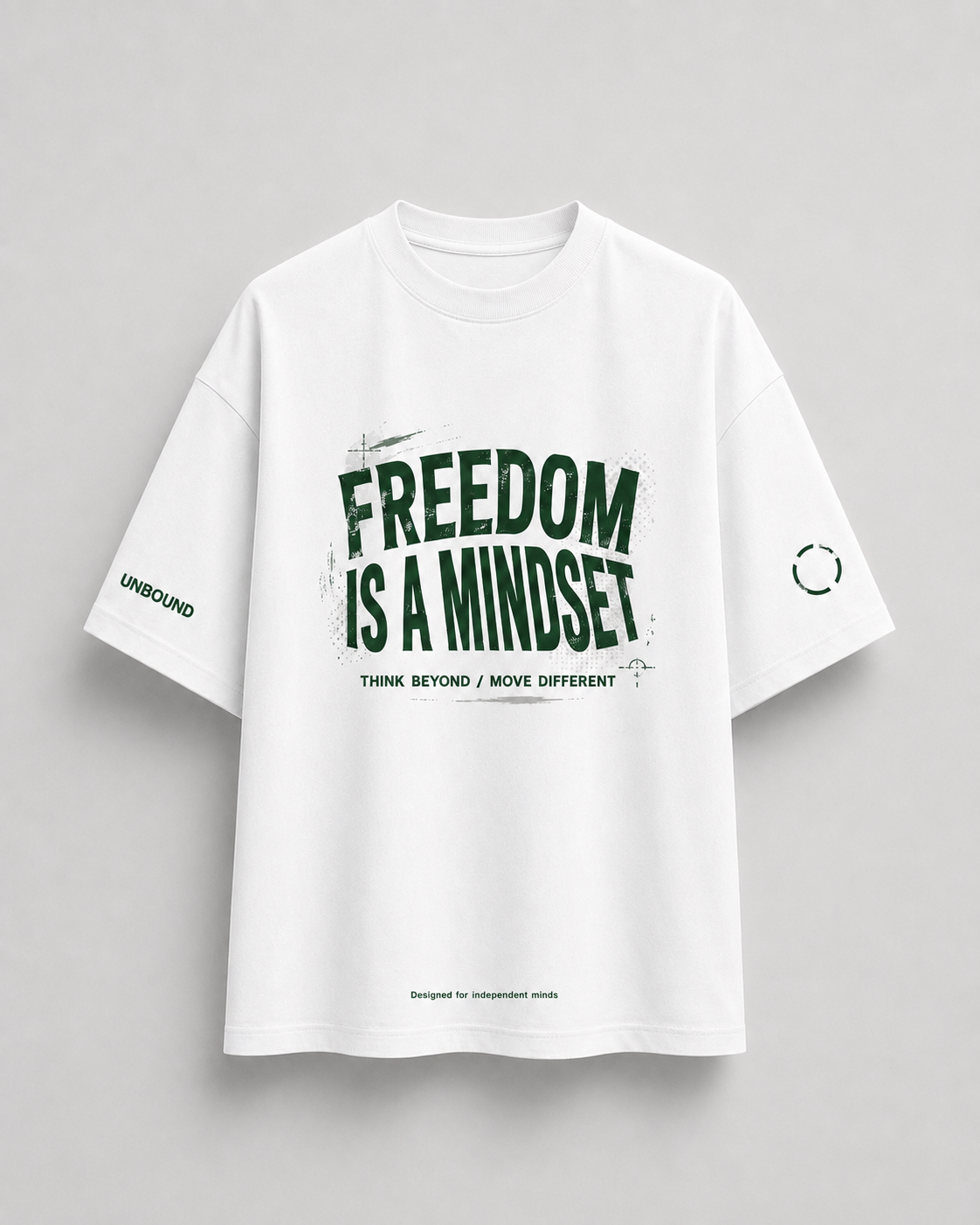 A white oversized short-sleeve t-shirt with a dark green graphic print on the front reading 'FREEDOM IS A MINDSET' and smaller text below, shown against a light gray background.