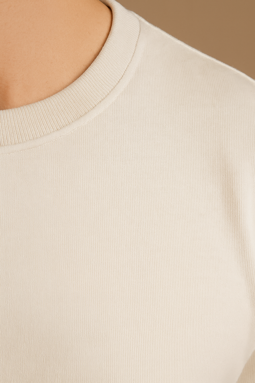 Close-up of a beige sweater with a neutral background