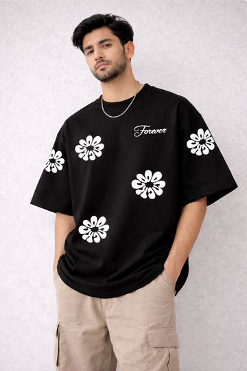 Person wearing a black t-shirt with white floral patterns and text on a light gray background