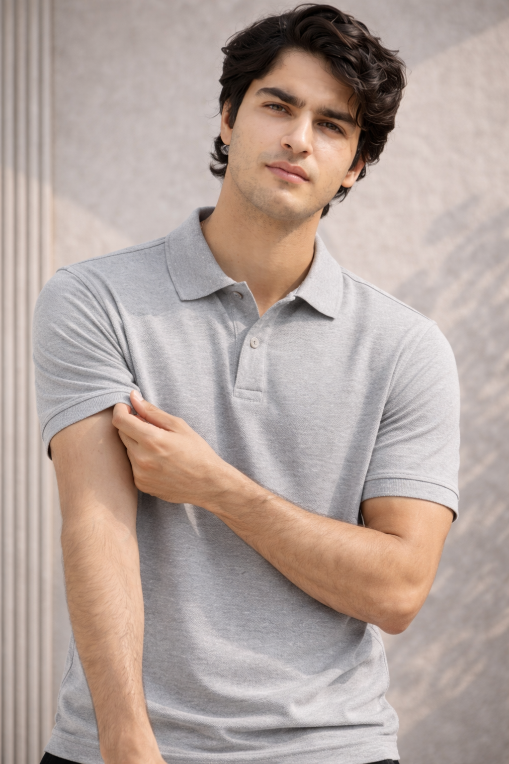 Man wearing a gray polo shirt against a neutral background