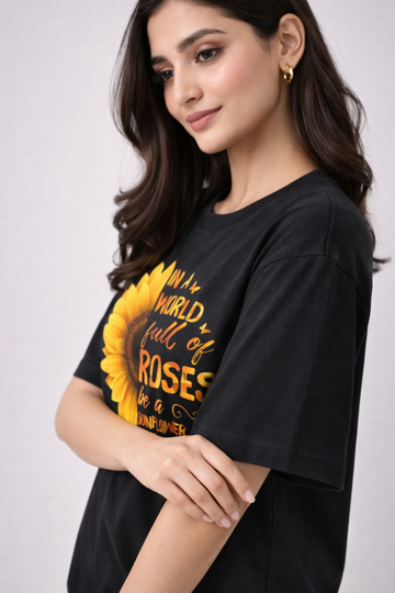 Woman wearing a black t-shirt with a sunflower graphic and text.