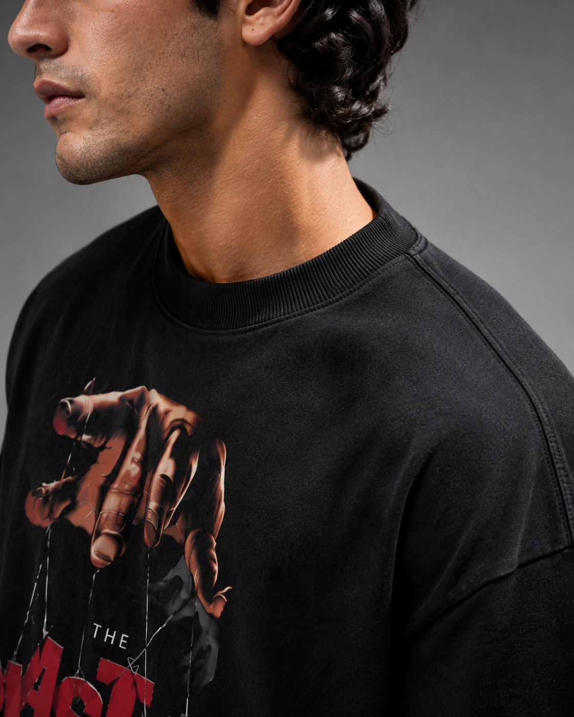 Person wearing a black sweatshirt with a graphic design on a gray background