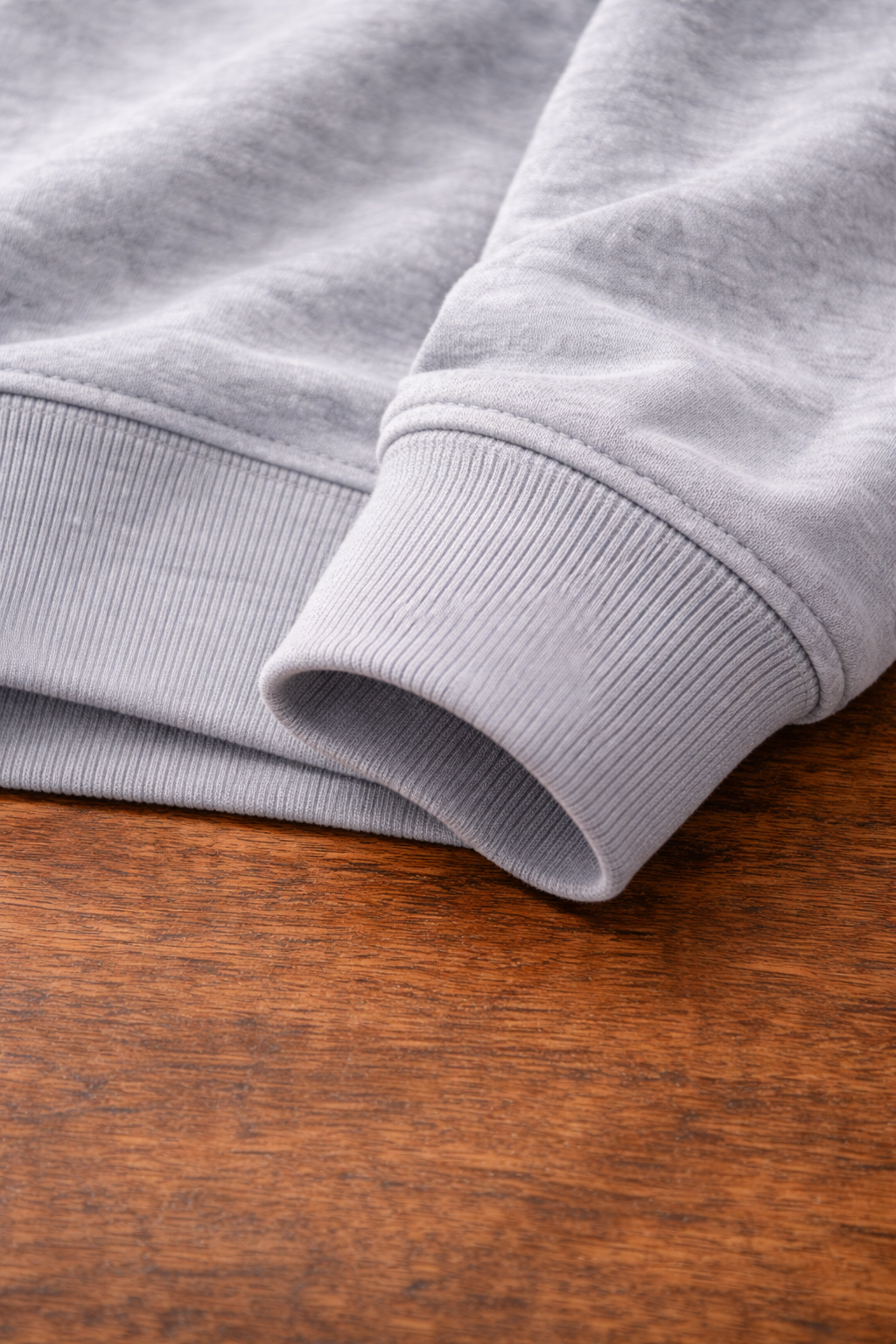 Folded gray sweatshirt on a wooden surface