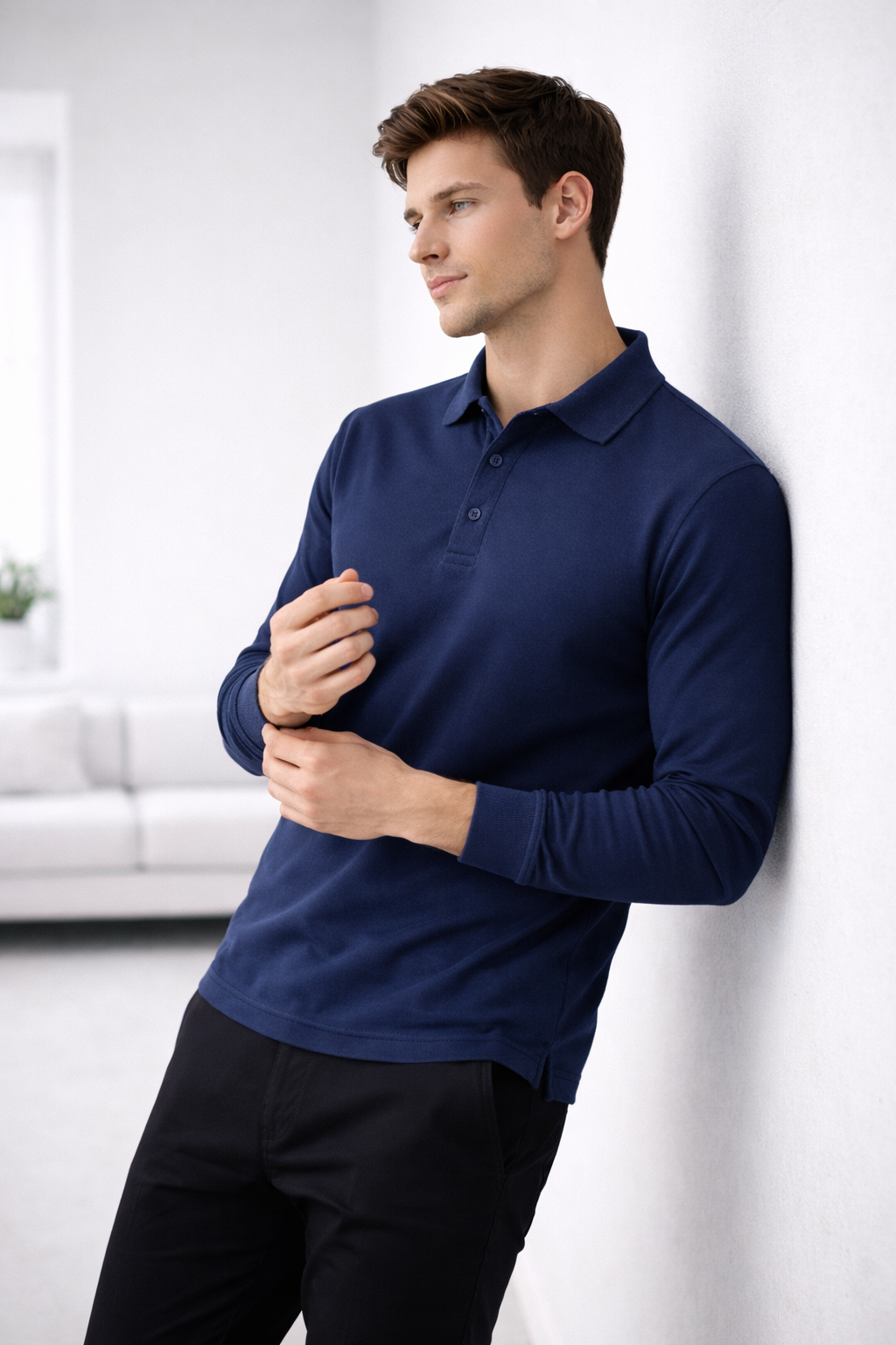 Man wearing a blue long-sleeve polo shirt against a white background