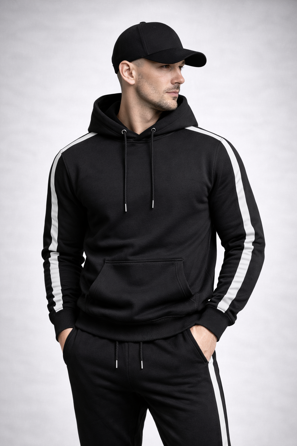 Man wearing a black hoodie with white stripes on a light gray background