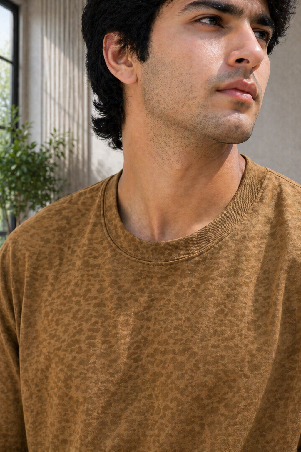 Man wearing a brown sweater with a blurred background