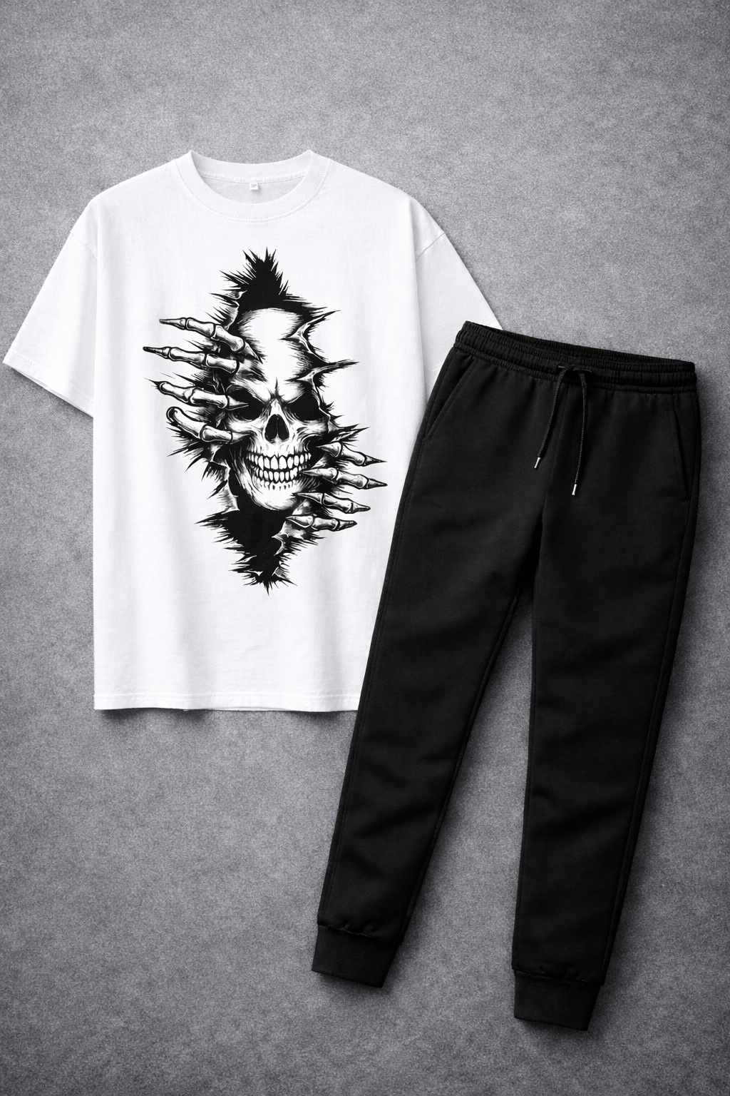 White t-shirt with black skull design and black pants on a gray background