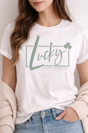 Person wearing a white t-shirt with 'Lucky All Day Everyday' text and shamrock graphic.
